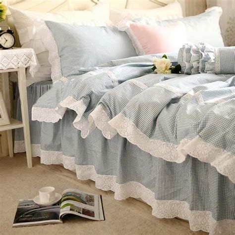 A Bed With Blue And White Ruffled Sheets