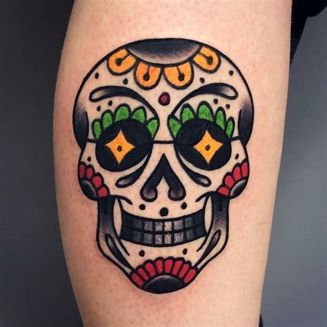 A Skull Tattoo On The Leg Of A Woman S Leg With An Orange And Green