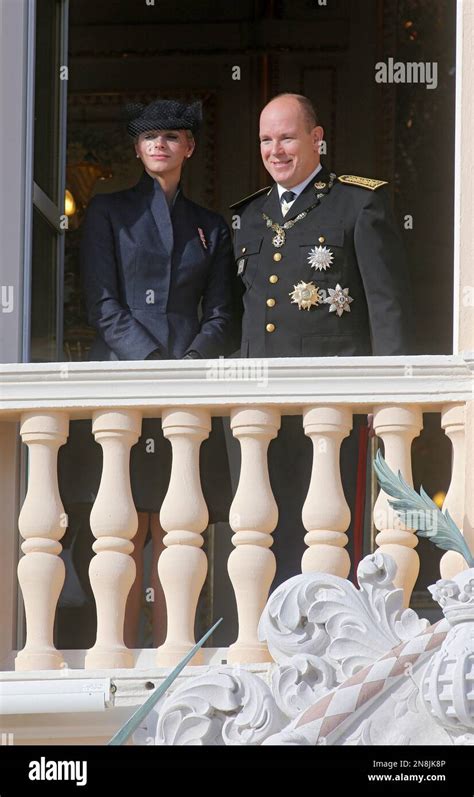 Prince Albert II of Monaco with his wife Princess Charlene look out from the Monaco palace to ...