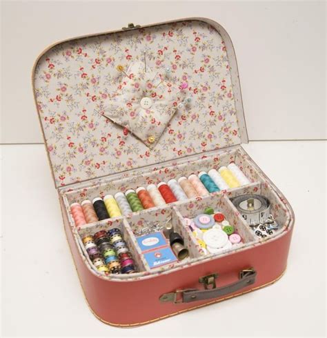 An Open Suitcase Filled With Lots Of Crafting Supplies On Top Of A