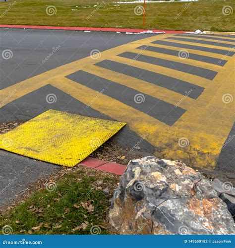 Square Paved Road Painted With Yellow Diagonal Stripes Between Parallel