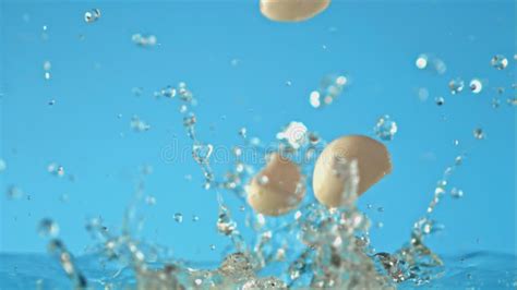 Super Slow Motion Garlic Falls On Water On Blue Background Filmed On A