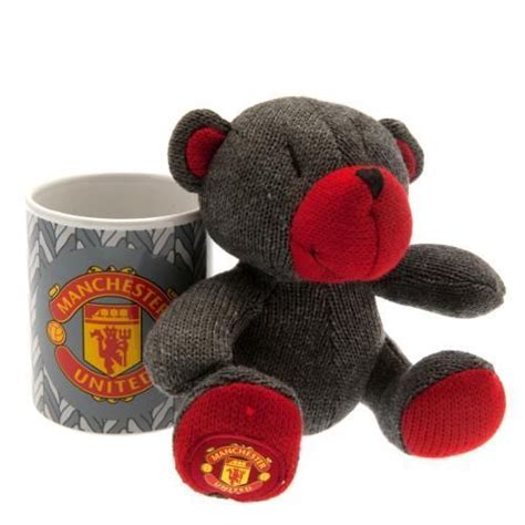 A Teddy Bear Sitting Next To A Coffee Cup With The Manchester United