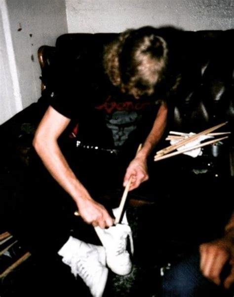 A Man Sitting On Top Of A Couch Holding A Pair Of Chopsticks In His Hand