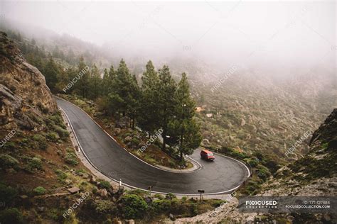 Car driving on winding road in mountains on foggy day — drive, travel ...