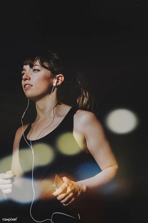 a woman wearing headphones and listening to music on her earphone while ...