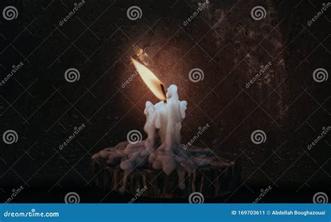 A Shining Isolated Burning Candle Light On The Wood While It`s Raining