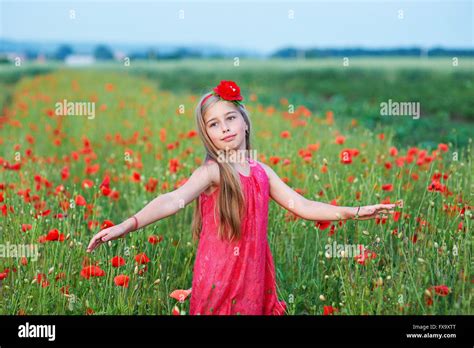 Beautiful Girl In Red Dress Walks At Poppy Field Stock Photo Alamy