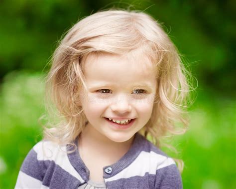 Petite Fille Blonde Assez De Sourire Avec Le Lilas De Floraison Photo