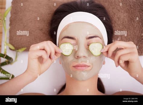 Beautiful Young Woman In Clay Mud Mask On Face Covering Eyes With