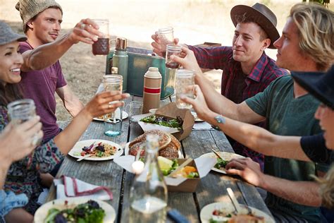 Group Of Friends Having A Picnic In The Park Together By Stocksy