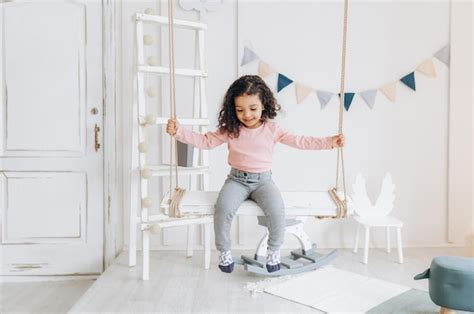 Une Petite Fille La Peau Fonc E Monte Sur Une Balan Oire Design D