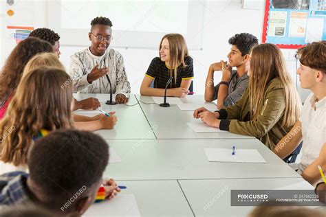 Studenti Delle Scuole Superiori Che Parlano A Tavola In Classe