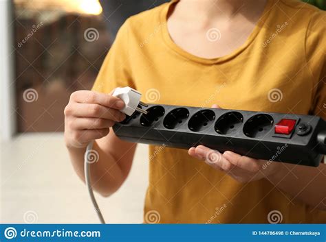 Woman Inserting Power Plug Into Extension Cord Indoors Space For Text