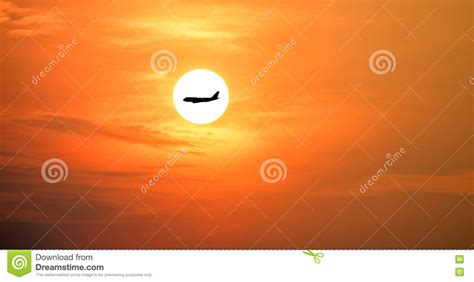 Silueta Del Aeroplano En El Sol Hermoso Y El Cielo Rojo Foto De Archivo