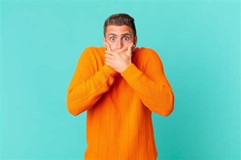 Premium Photo Young Handsome Man Covering Mouth With Hands With A Shocked