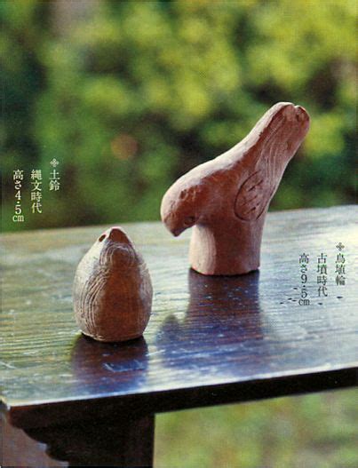 Two Clay Figurines Sitting On Top Of A Wooden Table