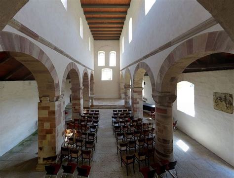 An Empty Church With Rows Of Chairs And Arches