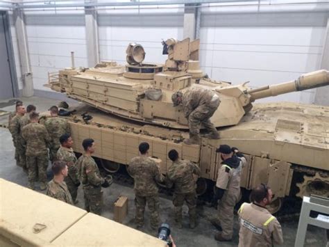 U.S. Soldiers install reactive armor tiles on its Abrams tanks