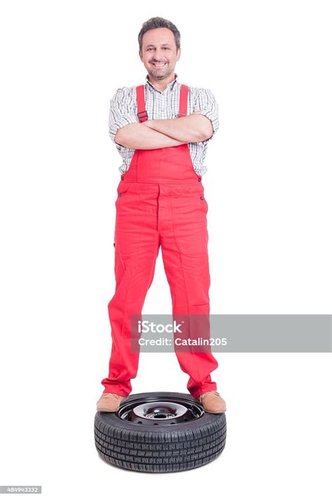 Mechanic Standing Proud And Confident On A Car Wheel Stock Photo