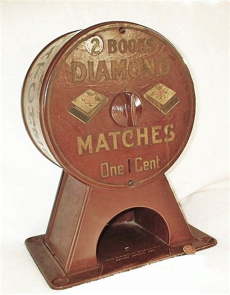 An Old Fashioned Match S One Cent Machine Sits On A White Background