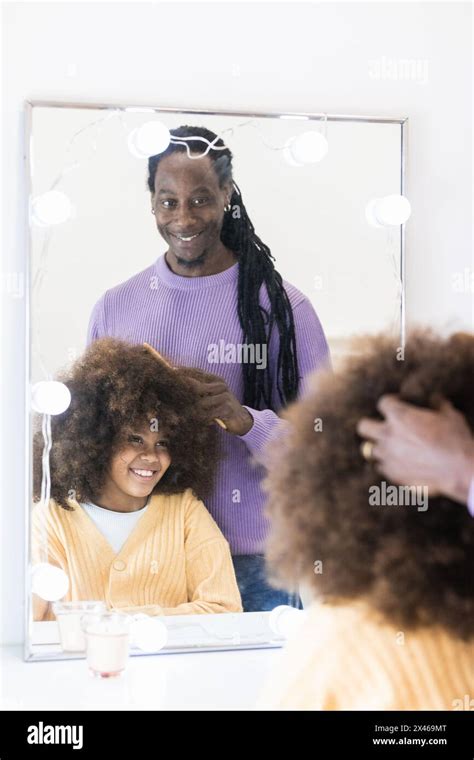 Crop African American father combing curly hair of girl sitting near ...