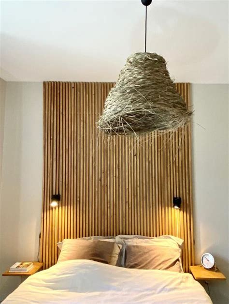 A Bed That Has Some Kind Of Thing Hanging From It S Headboard Above It