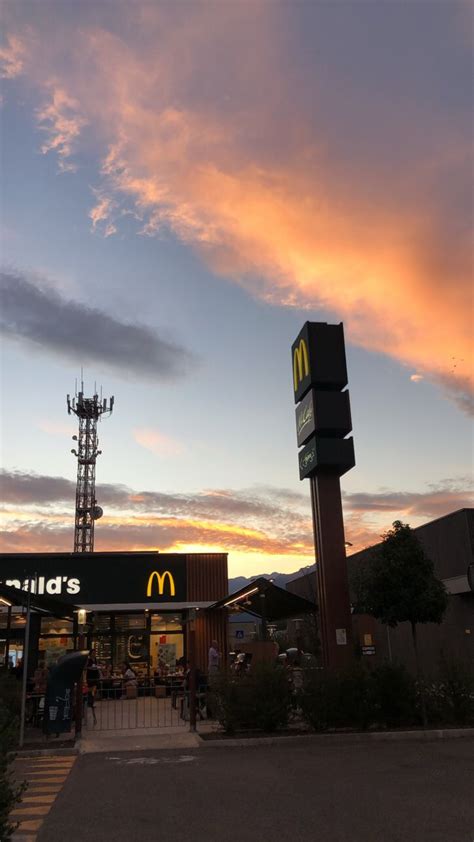 A Mcdonald S Restaurant At Sunset With The Sky In The Background And