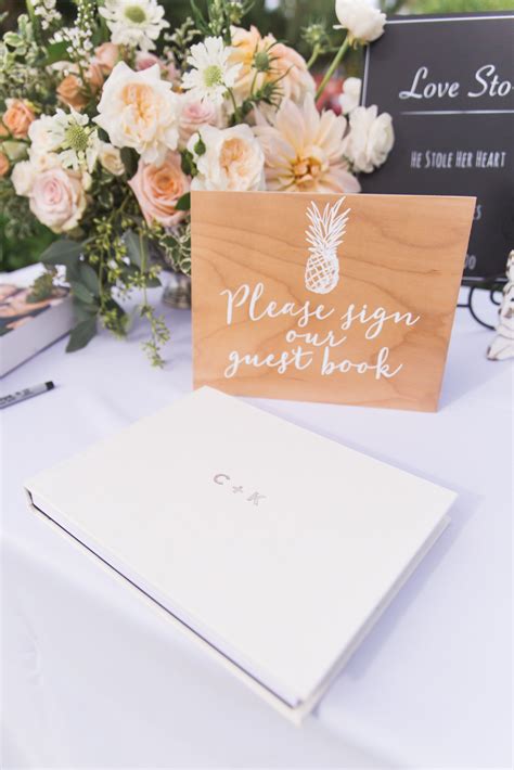 Wedding Welcome Table With Guest Book Sign And Floral Arrangement