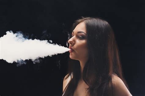 Premium Photo Brunette Woman Vaping Electronic Cigarette With Smoke