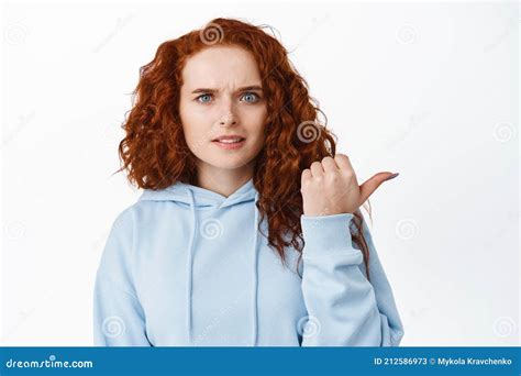 Confused Redhead Curly Girl Showing Something Strange Pointing Right