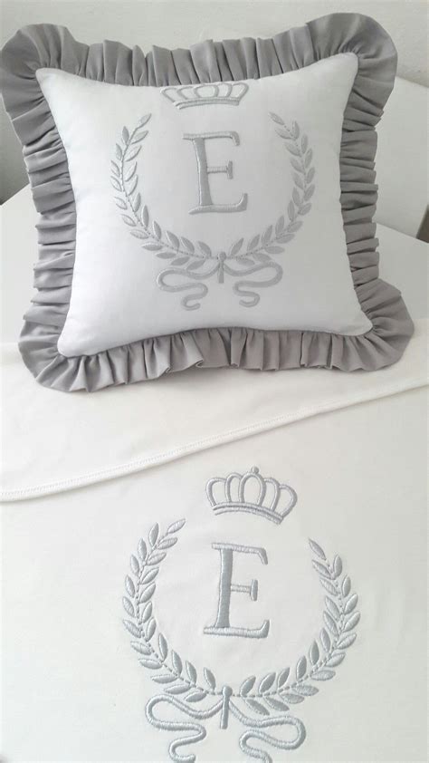 A White Bed Topped With Two Pillows And A Decorative Pillow On Top Of