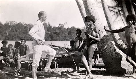 An Old Black And White Photo Of Men On The Beach With Palm Trees In The