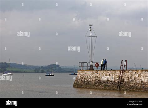 Couple on harbour wall at high tide at Lympstone Stock Photo - Alamy