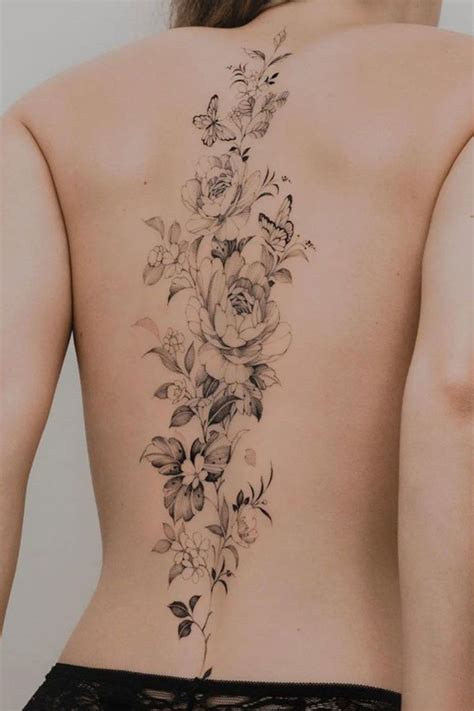 A Woman S Back Tattoo With Flowers And Butterflies On Her Lower Back