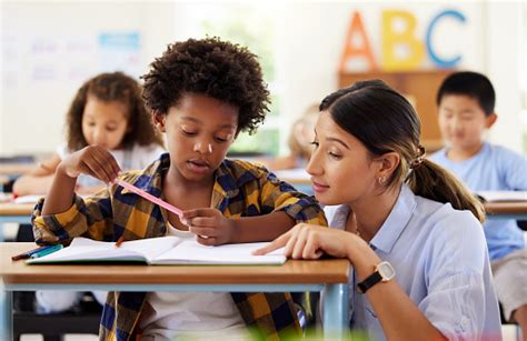 Foto De Una Maestra Ayudando A Una Alumna De Preescolar En Su Clase