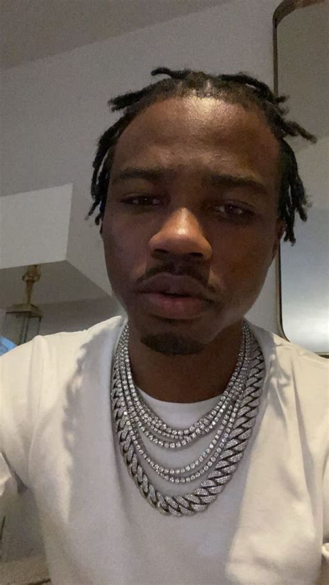 A Man With Dreadlocks Wearing A White T Shirt And Some Necklaces