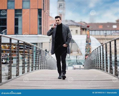 Photo Of A Man Walking Across A Bridge While Talking On A Cell Phone