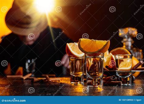 Vidrios De Tequila Con Los Palillos De La Naranja Y De Canela En Una