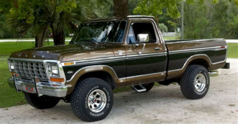 A Brown And Black Truck Parked Next To A Tree