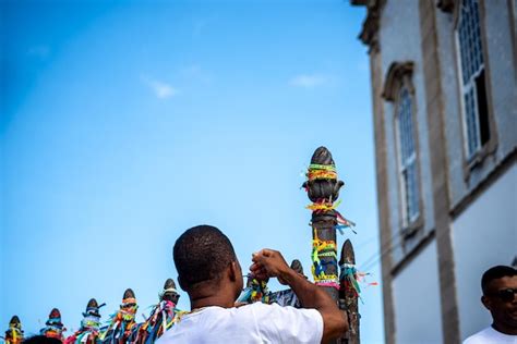 Fiéis amarram fitas coloridas no parapeito da igreja do senhor do