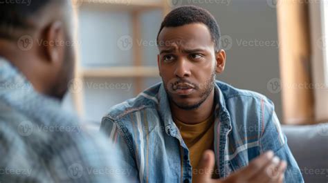 Two men engage in a group therapy session openly discussing their