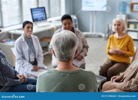 Senior Woman Sitting In Circle At Mental Health Support Group In