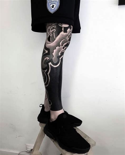 A Man With Tattoos On His Legs And Leggings