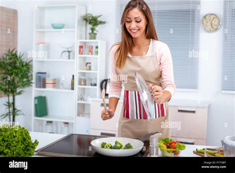 Young beautiful woman cooking healthy meal in the kitchen Stock Photo ...