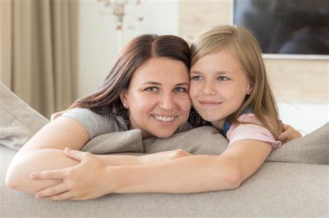 Madre E Hija Pre Adolescente Que Se Sientan En La Sonrisa Del Sof