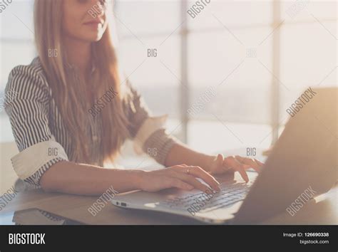 Female Writer Typing Using Laptop Keyboard At Her Workplace In The