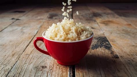 Premium Photo Cooked Rice In A Red Cup Placed On The Plywood Floor