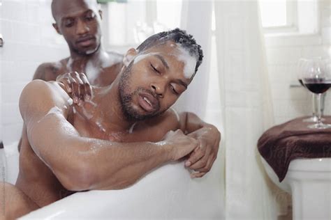 Gay Couple Giving Backrub While Bathing Together In A Bath Tub By