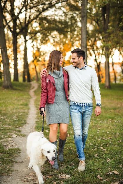 Premium Photo | Couple enjoying walking the dog in the park